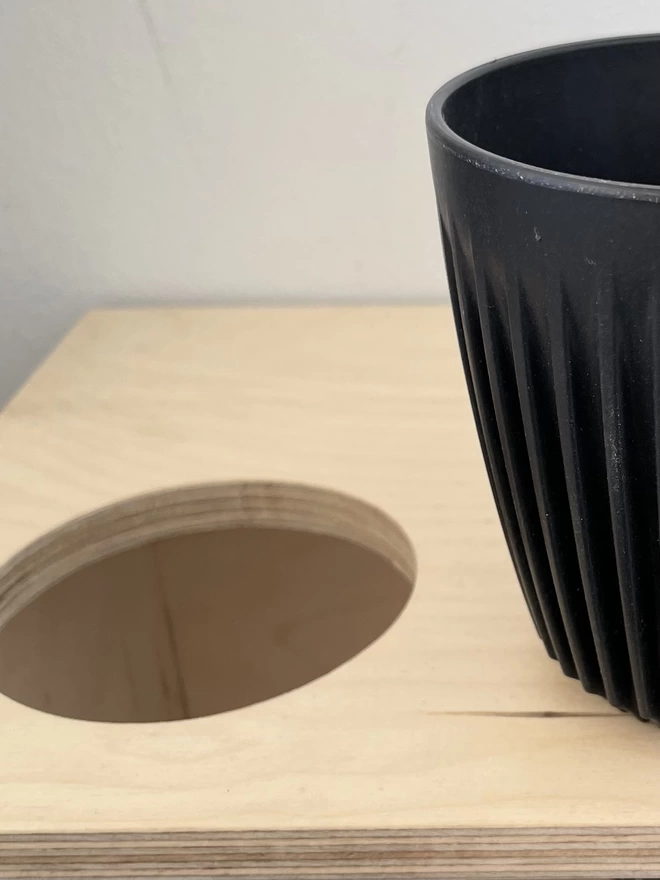 close up on cup holder with black beaker on the side 