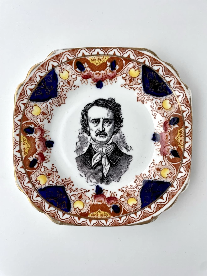 vintage plate with an ornate border, with a printed vintage illustration of Edgar Allen Poe in the middle 