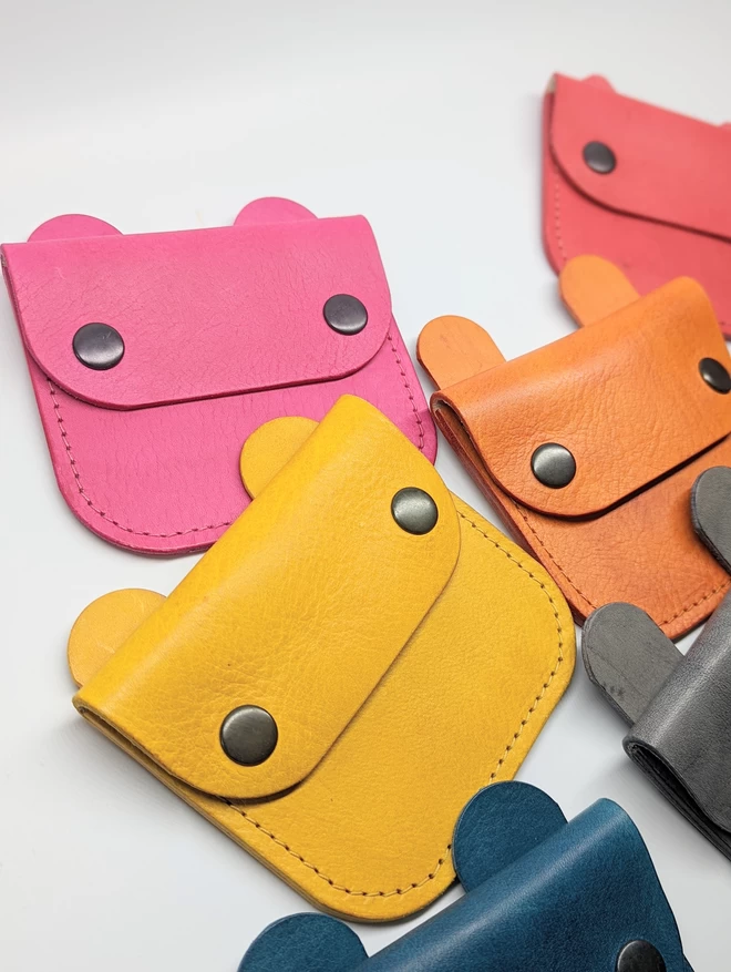 Image of assorted Notch Handmade leather animal purses in various hand- dyed colours.