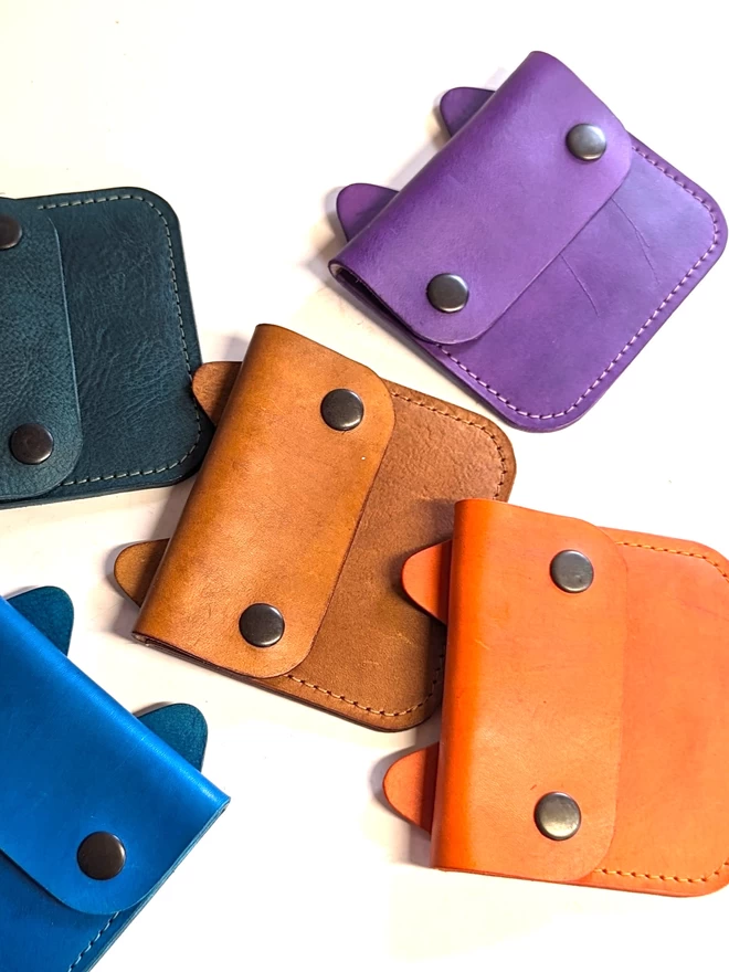 Front view of leather Cat purses in assorted colours.