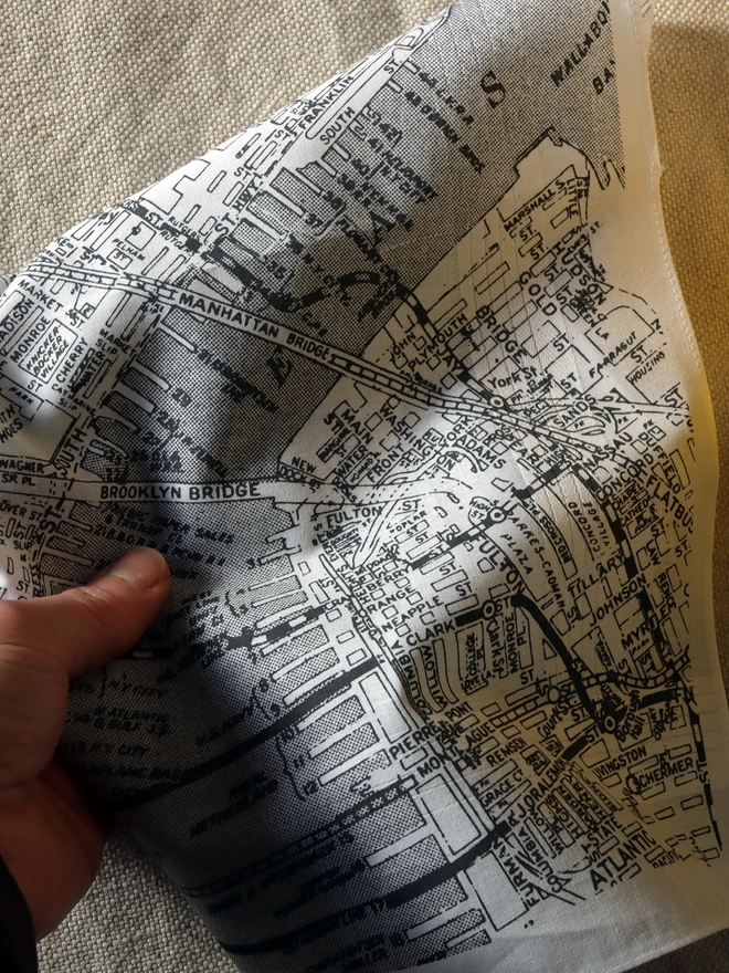 A printed cotton handkerchief showing a map of New York city in grey.