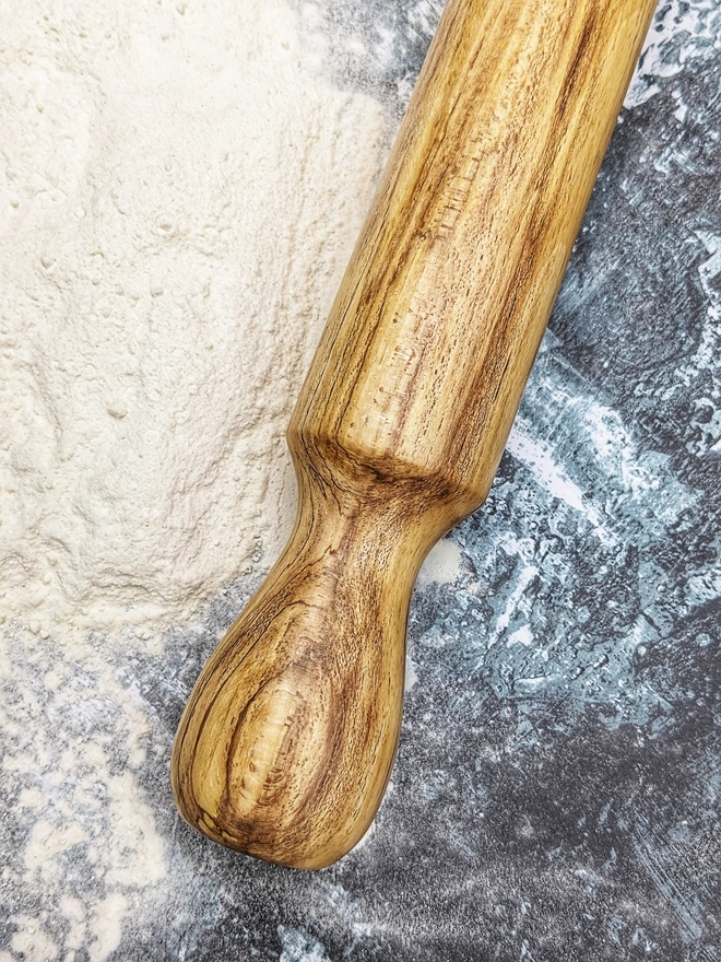 A close up of a stunning hand made rolling pin in Spalted Beech by Something From The Turnery. Displaying the all-natural detailing on the left hand side of the rolling pin. 