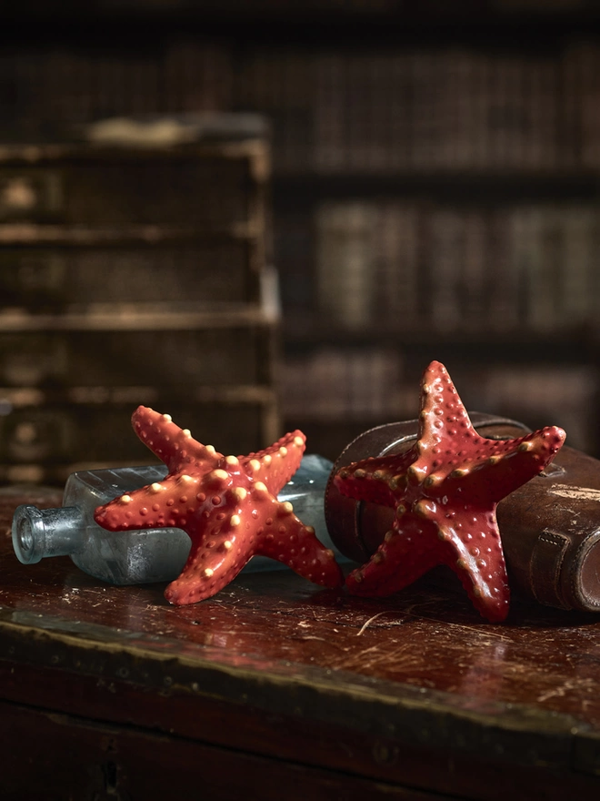 Realistic edible chocolate starfish on antique bottles on a table