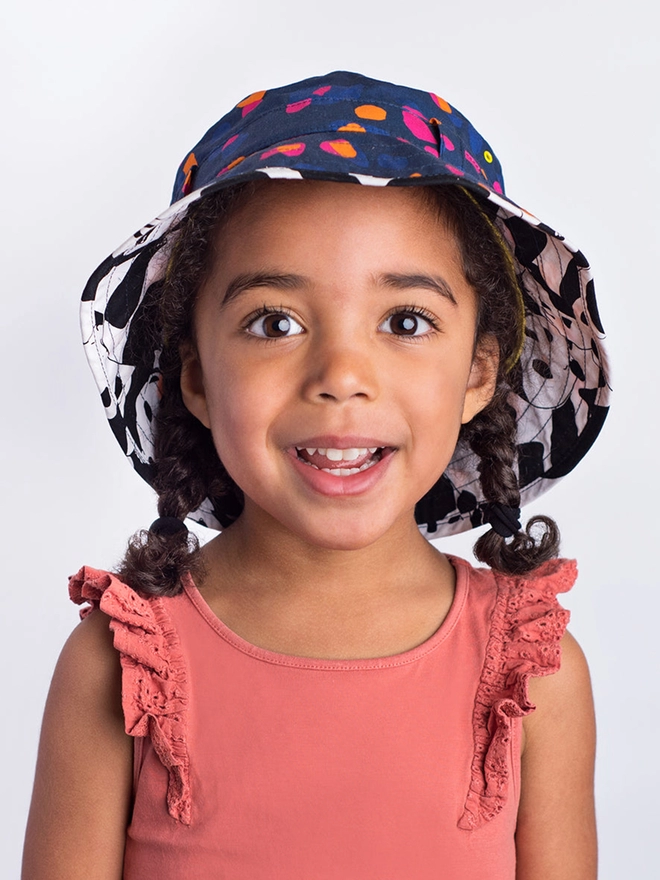 Girl wearing sun bucket hat in spot print