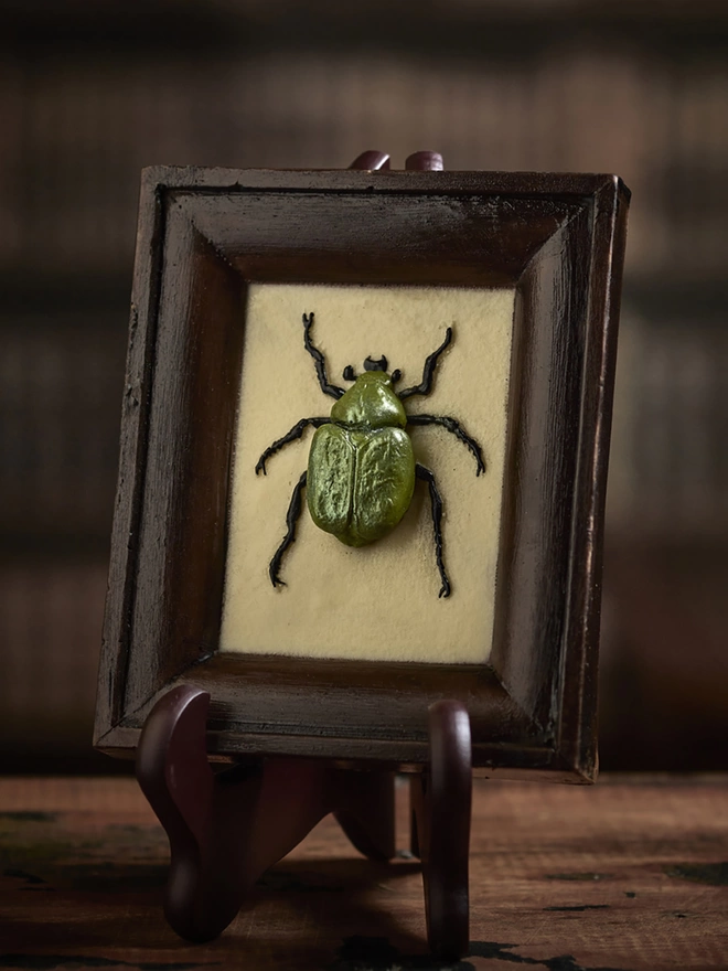 Realistic edible chocolate Chafer beetle in chocolate frame on antique background