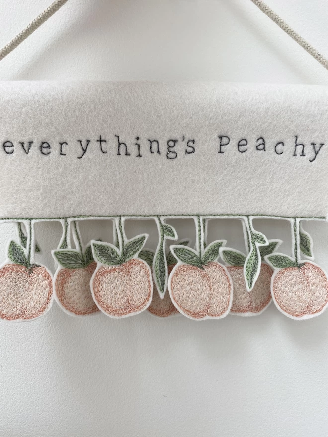 Close up of everything's peachy banner against wall.