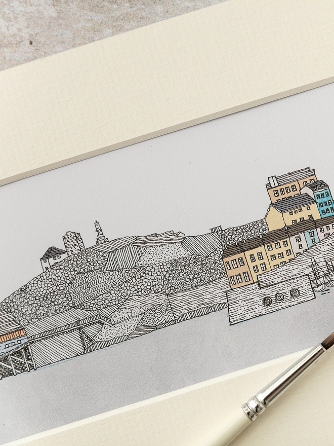 Print of detailed pen and watercolour drawing of Tenby harbour and cliffside houses in a soft white mount