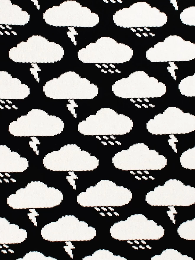 A close up of the pattern detail showing the reverse colourway of the knitted monochrome storm cloud blanket, white pattern on black background.