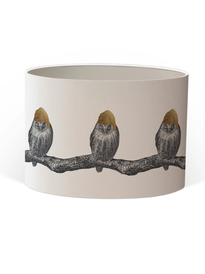 Drum Lampshade featuring little owls wearing a gold nightcap sitting on a branch with a white inner on a white background