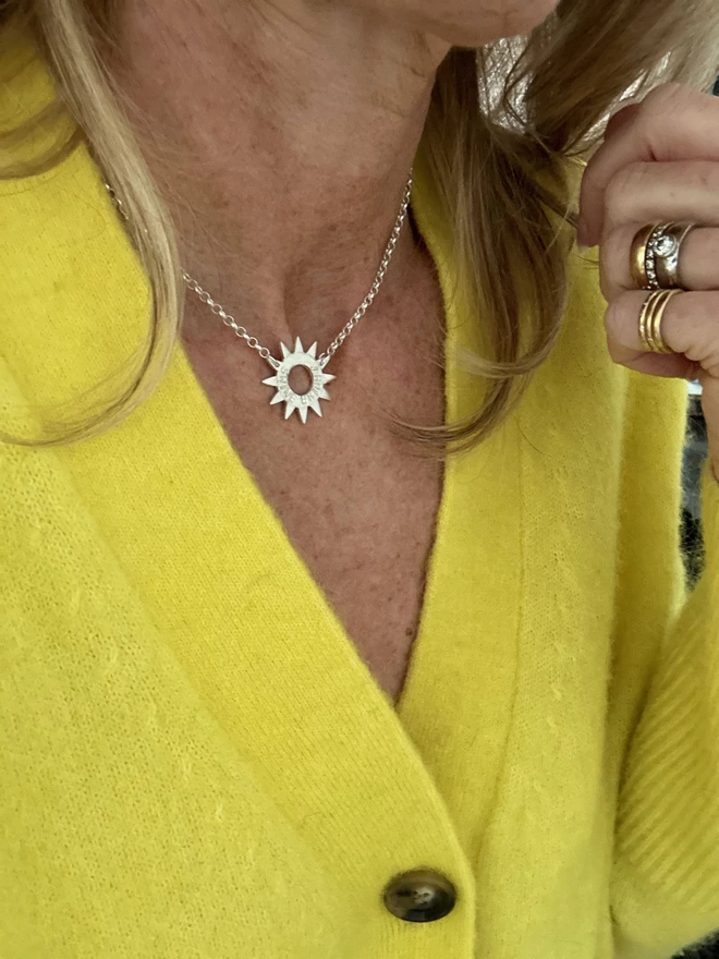 model wearing sterling silver sun charm on sterling silver chain