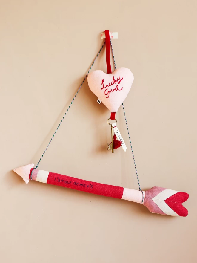 Linen arrow wall decoration in red and pink with l'amour de ma vie' embroidery
