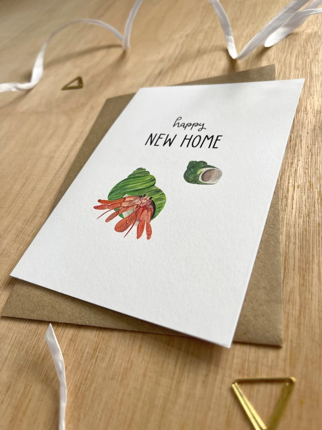 a greetings card featuring a hermit crab with the phrase “happy new home”