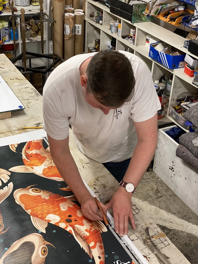 tony cutting out artwork with a knife in his workshop