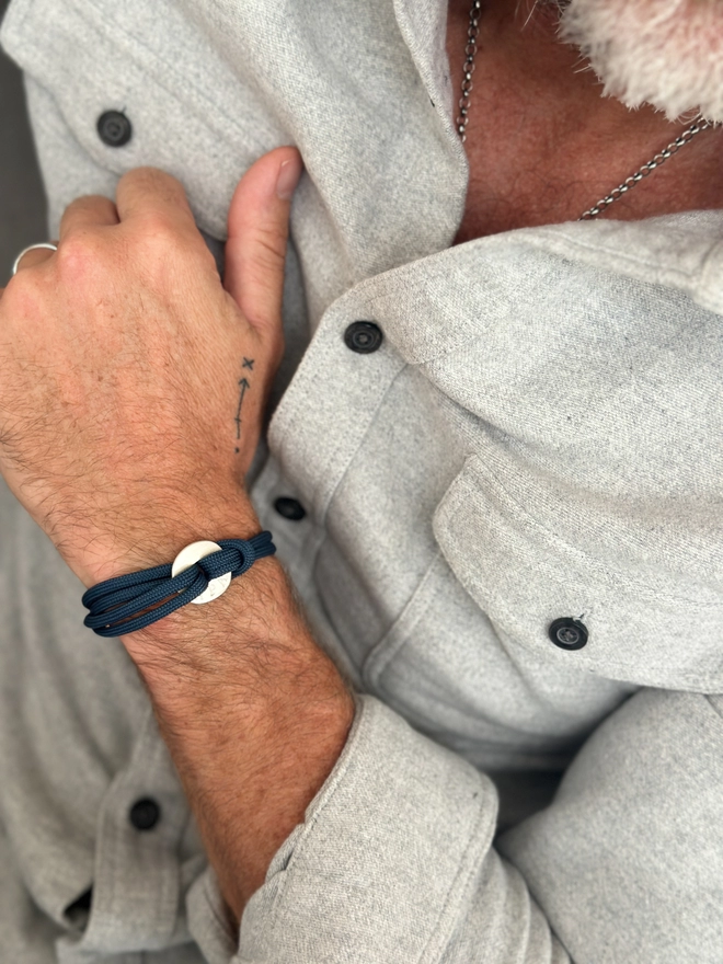 model wears personalised sterling silver polo charm bracelet on blue cord