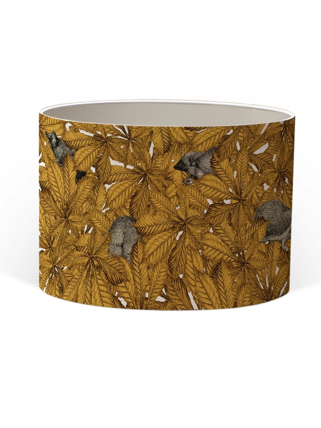 Drum Lampshade featuring hedgehogs in yellow autumn leaves with a white inner on a white background