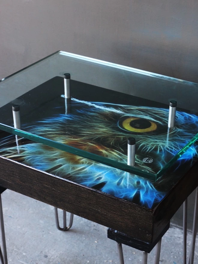 blue electric owl artwork showing through glass top
