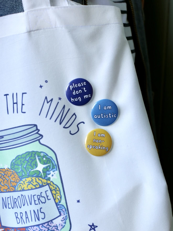 three badges on a tote bag