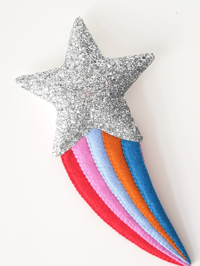 Silver shooting star decoration with a red, pink, blue, rust and dark blue tail