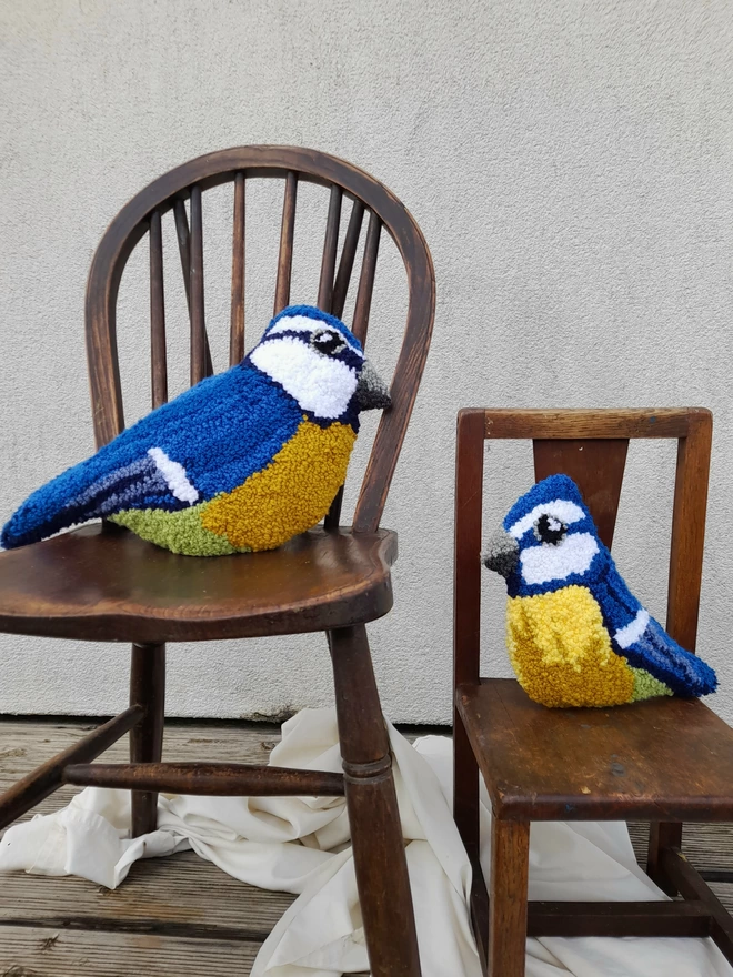 Large and Small Blue Tit Cushions Perched on Vintage Wooden Chairs