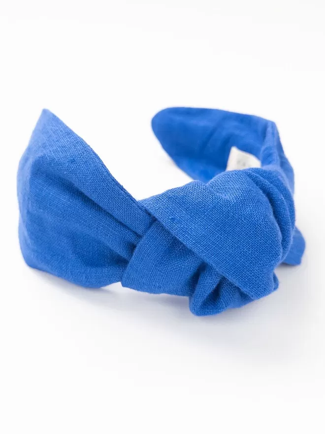 Vanessa Rose Amelie Hairband in French Blue seen flat with a close up of the knot.