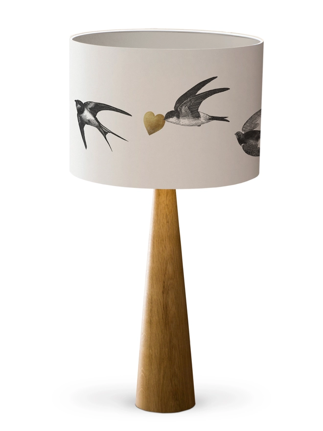 Drum Lampshade featuring Swallows with a white inner on a wooden base on a white background