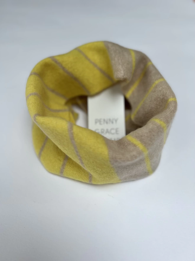 Yellow oatmeal knitted snood shown on a white background