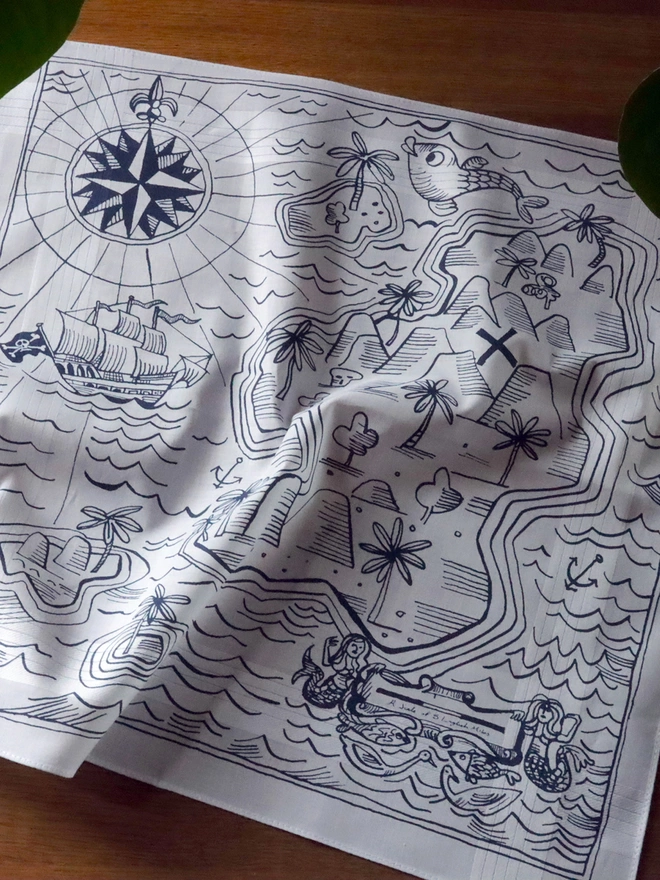 A cotton hankie screenprinted with an illustrated treasure map in midnight blue