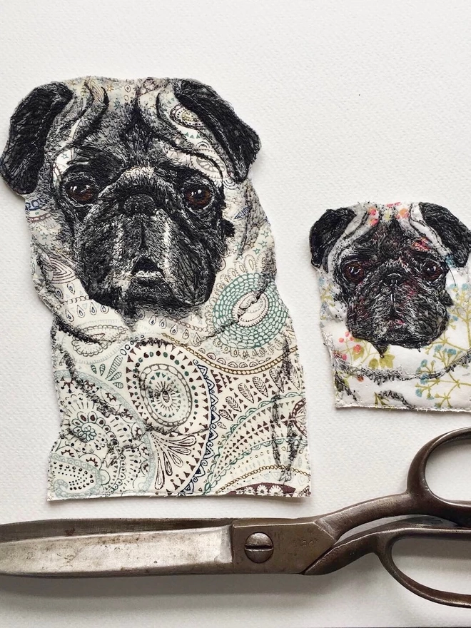 two embroidered pet portraits of pugs, one large, one small