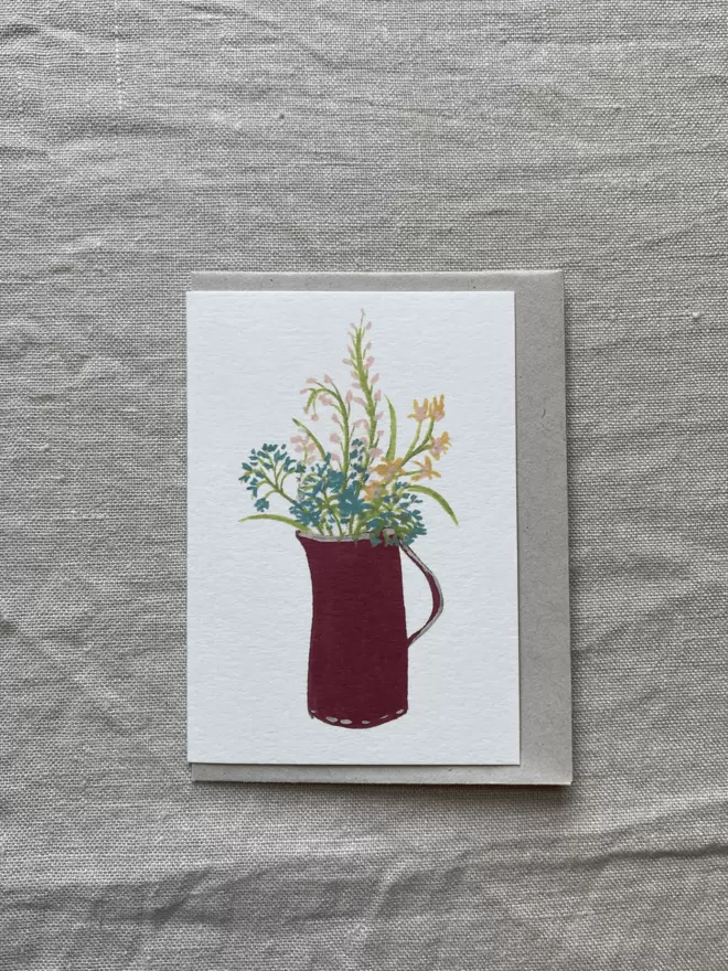 greetings card with a bunch of flowers in a red jug on it. 