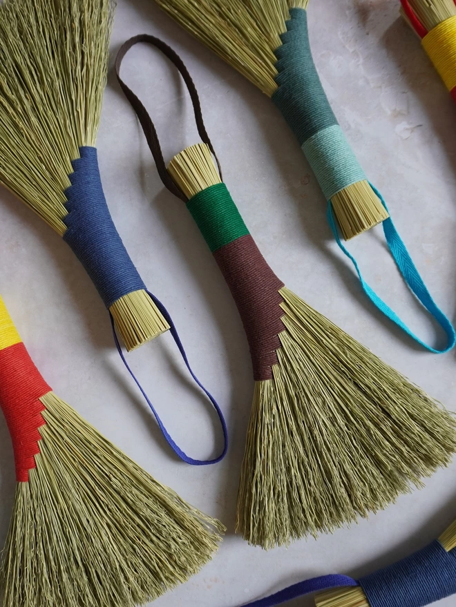 Four broomcorn brushes in a variety of bright colours