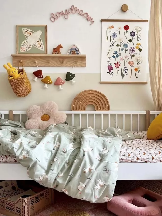 A lovely child's bedroom, styled up beautifully with a large, solid wood pegrail shelf, kid's prints and beautiful children's décor  