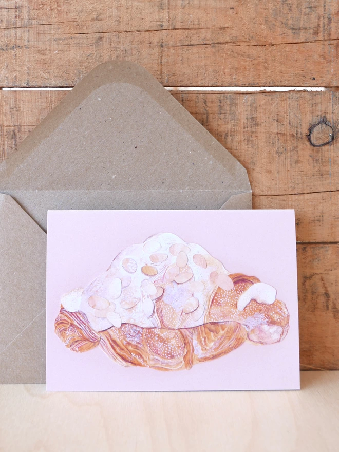 The Almond Croissant Card next to its brown envelope with front of card visible