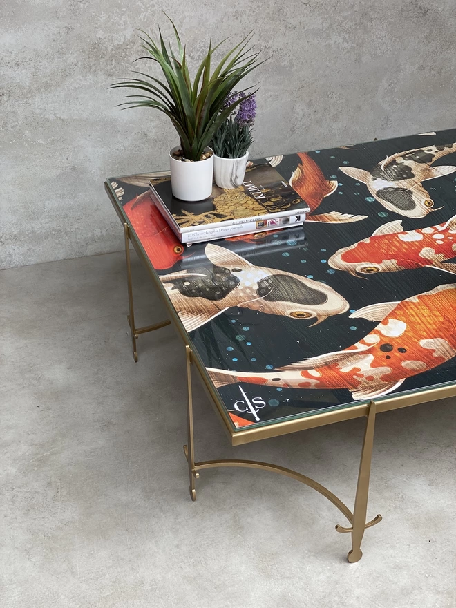 metal coffee table in gold with japanese fish artwork glass top