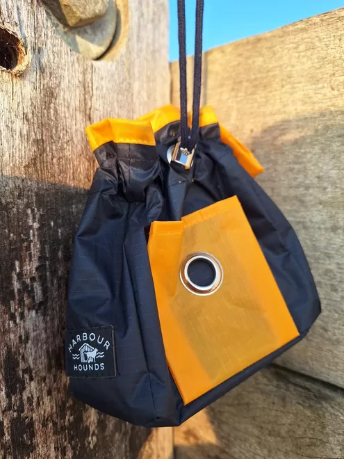 Orange/navy dog treat bag. Made from sail fabric this treat bag is waterproof. Large enough to hold treats and a ball. Front pocket holds poo bag roll. 