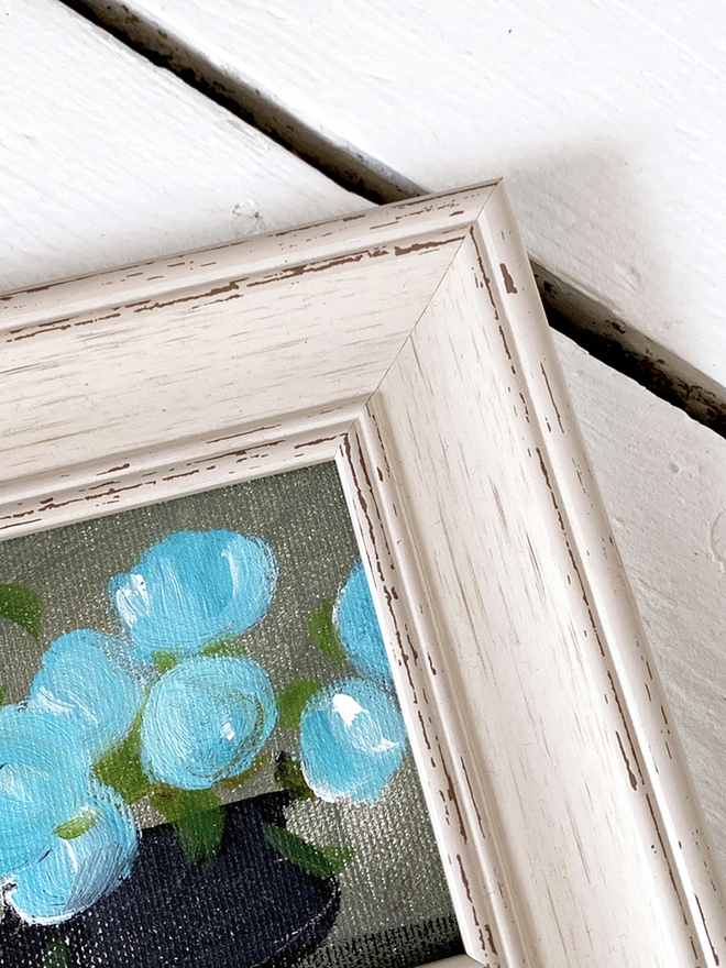 detail of painted flowers in chunky vintage cream frame