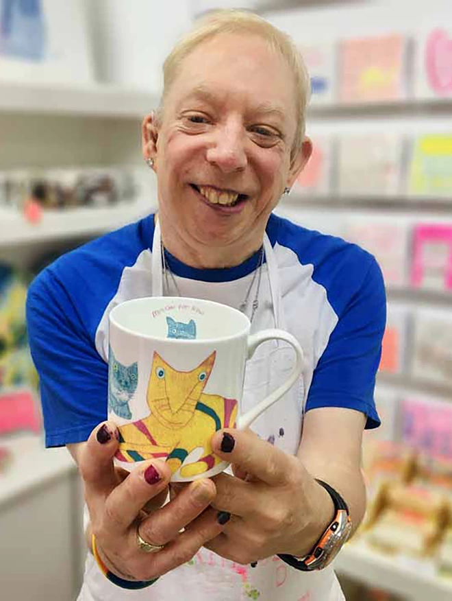 Happy artist holding charity miaow for now fine bone china cat gift mug featuring bright colour cats