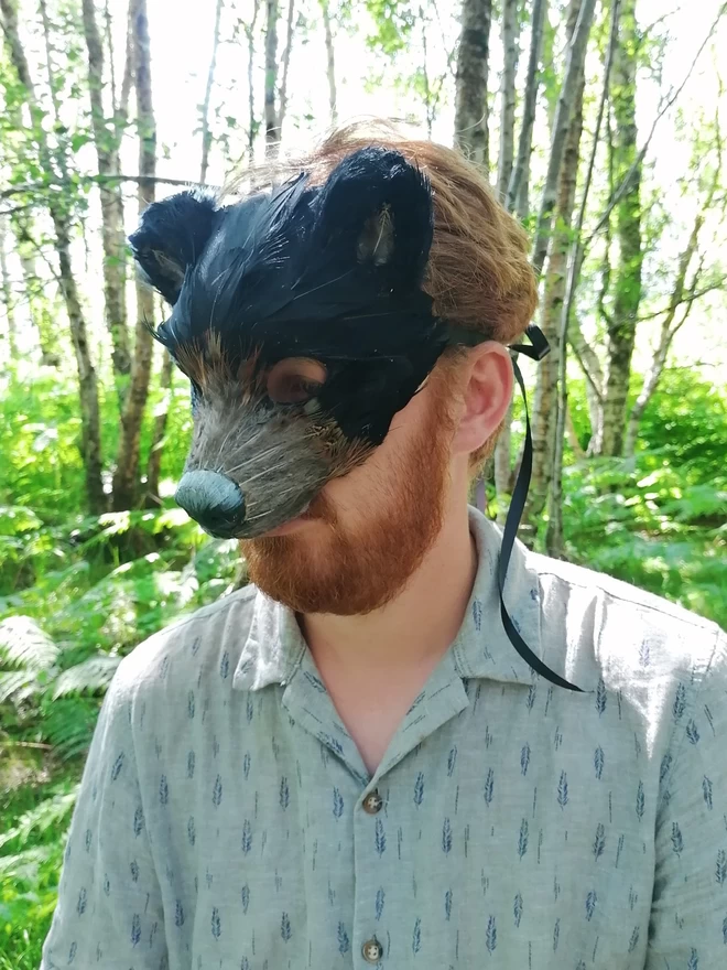 A man wearing a luxury black bear party mask down over his face