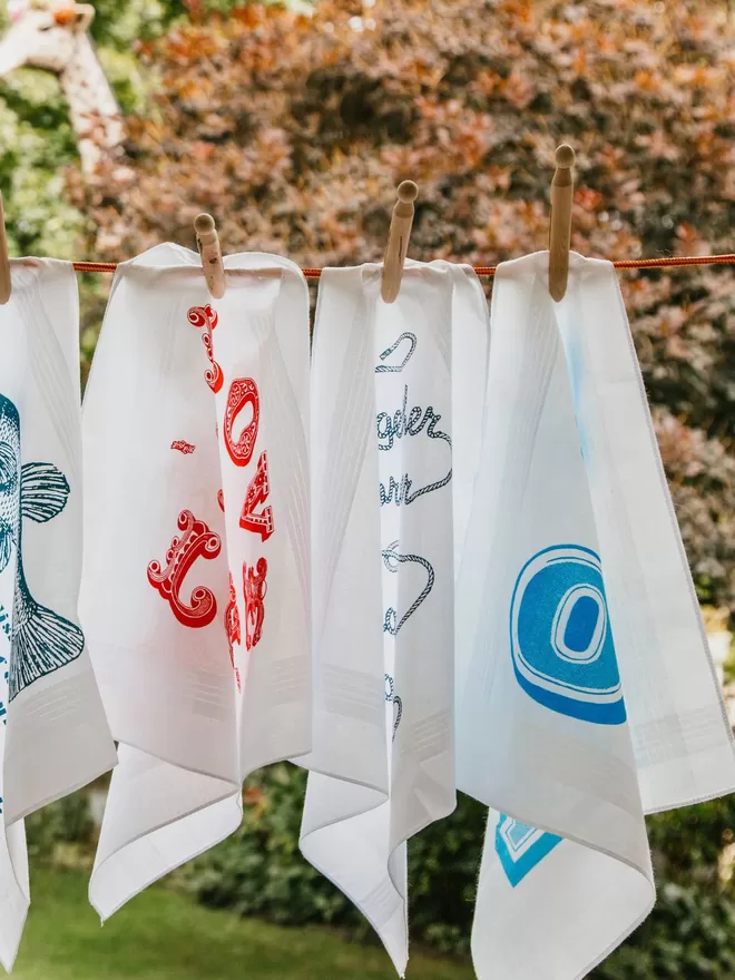 A Selection of Mr.PS printed handkerchiefs pegged on a washing line