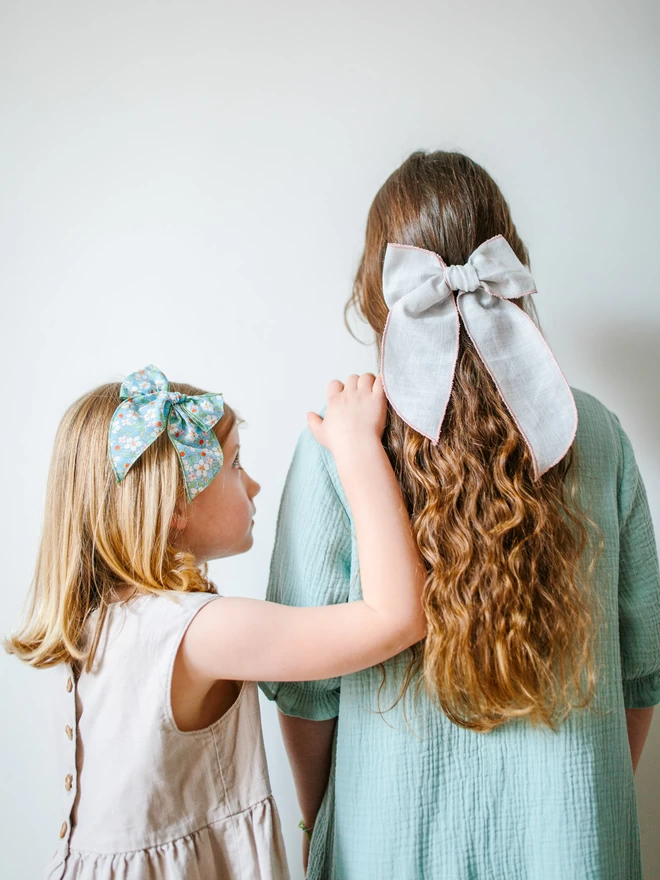 Two girls together with their bows