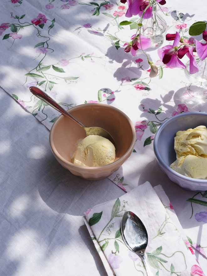 Table with bowls of ice cream on linens printed with sweet peas