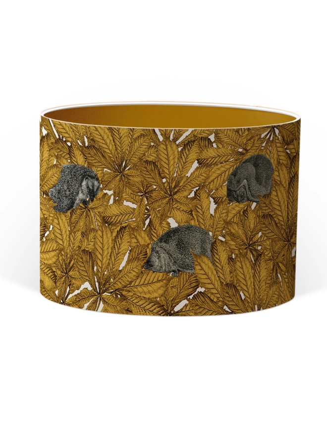 Drum Lampshade featuring hedgehogs in yellow autumn leaves with a Gold inner on a white background