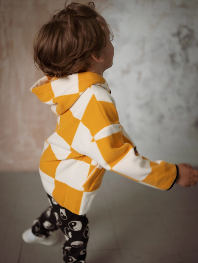 Another Fox Orange Checkerboard Polar Fleece Kids Hoody seen from the side on a child moving.
