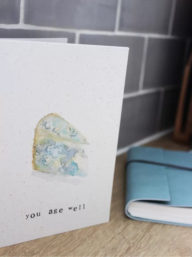'You Age Well' Card standing on wooden surface