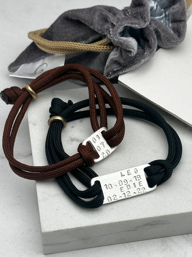 image shows the maxi and mini plate personalised men's friendship bracelets. one on brown, the other on black cord