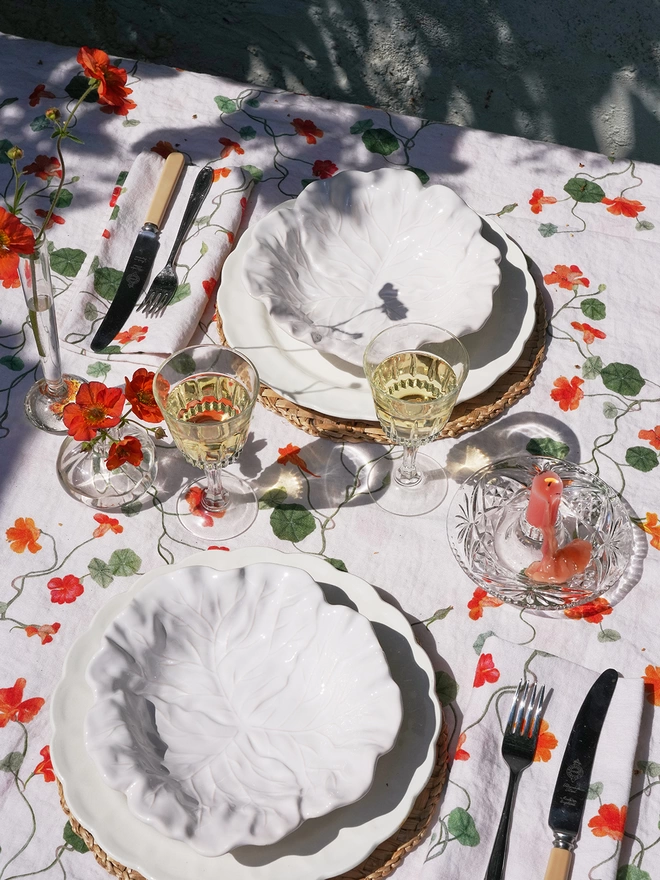 TABLE LAID WITH LINENS PRINTED WITH NASTURTIUM FLORALS