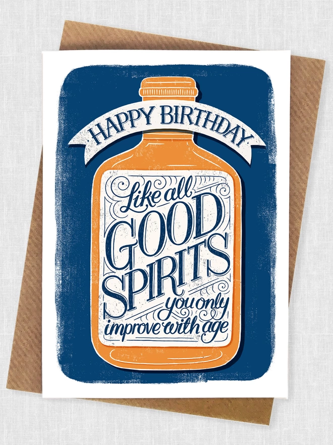 hand lettered birthday card with like all good spirits you only improve with age on the label in blue and orange