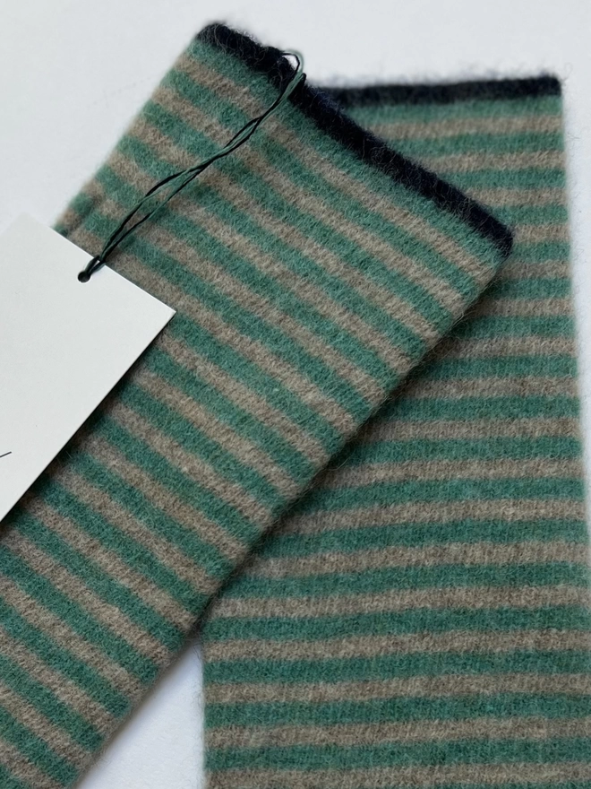 A close up of a pair of knitted striped wristwarmers
