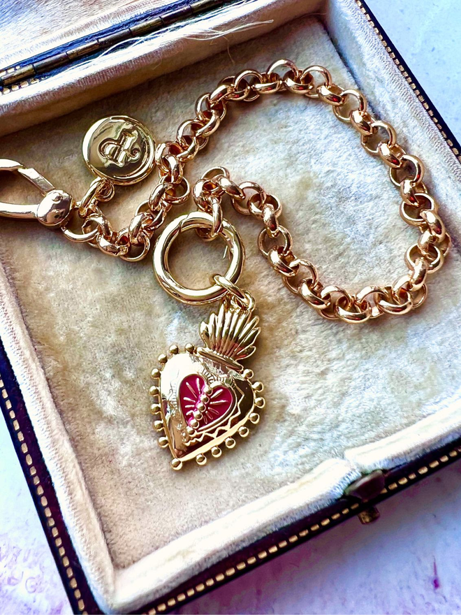 Mexican sacred heart to represent Frida Kahlo on a gold belcher chain bracelet inside a cream vintage jewellery box