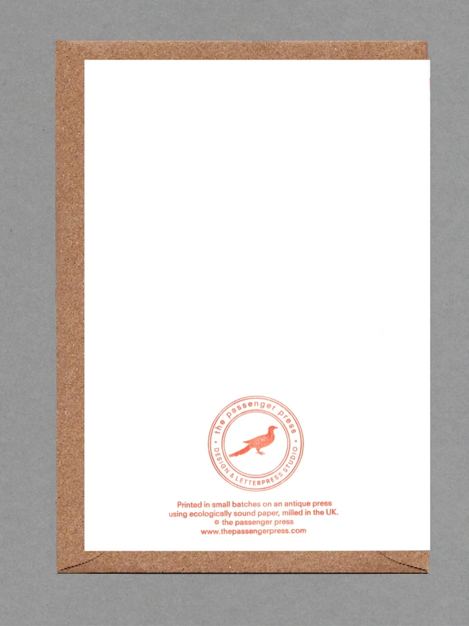 Back face of a white card on a brown envelope. Printed orange text, logo and QR code.