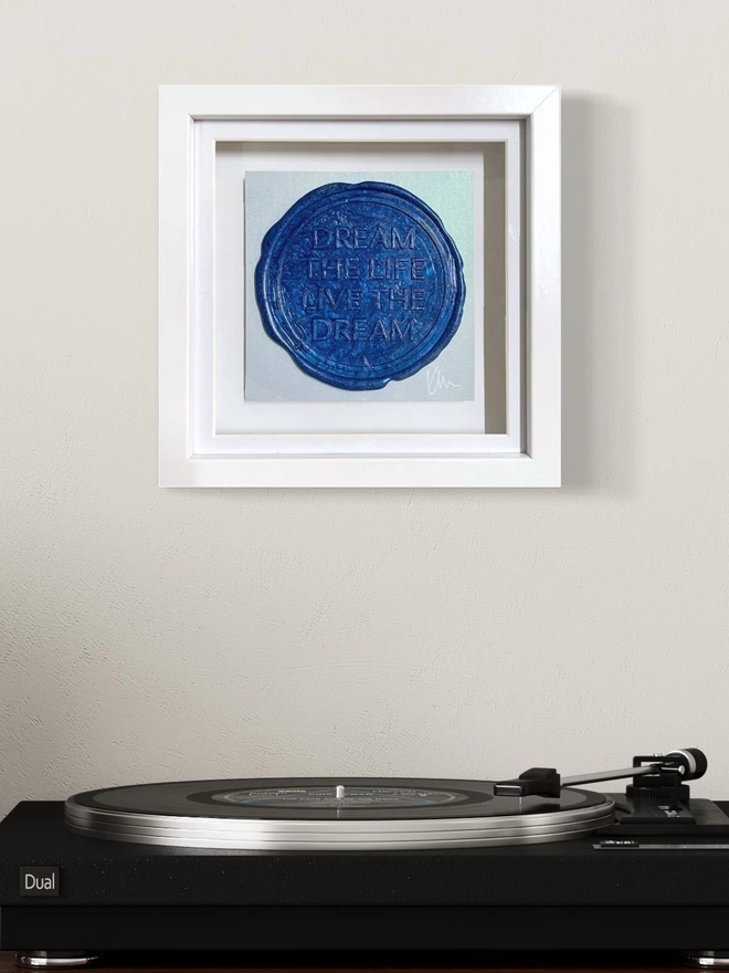     - [ ] Original artwork by Kate Mayer of the affirmation Dream the Life, Live the dream sealed in blue wax shown on a wall